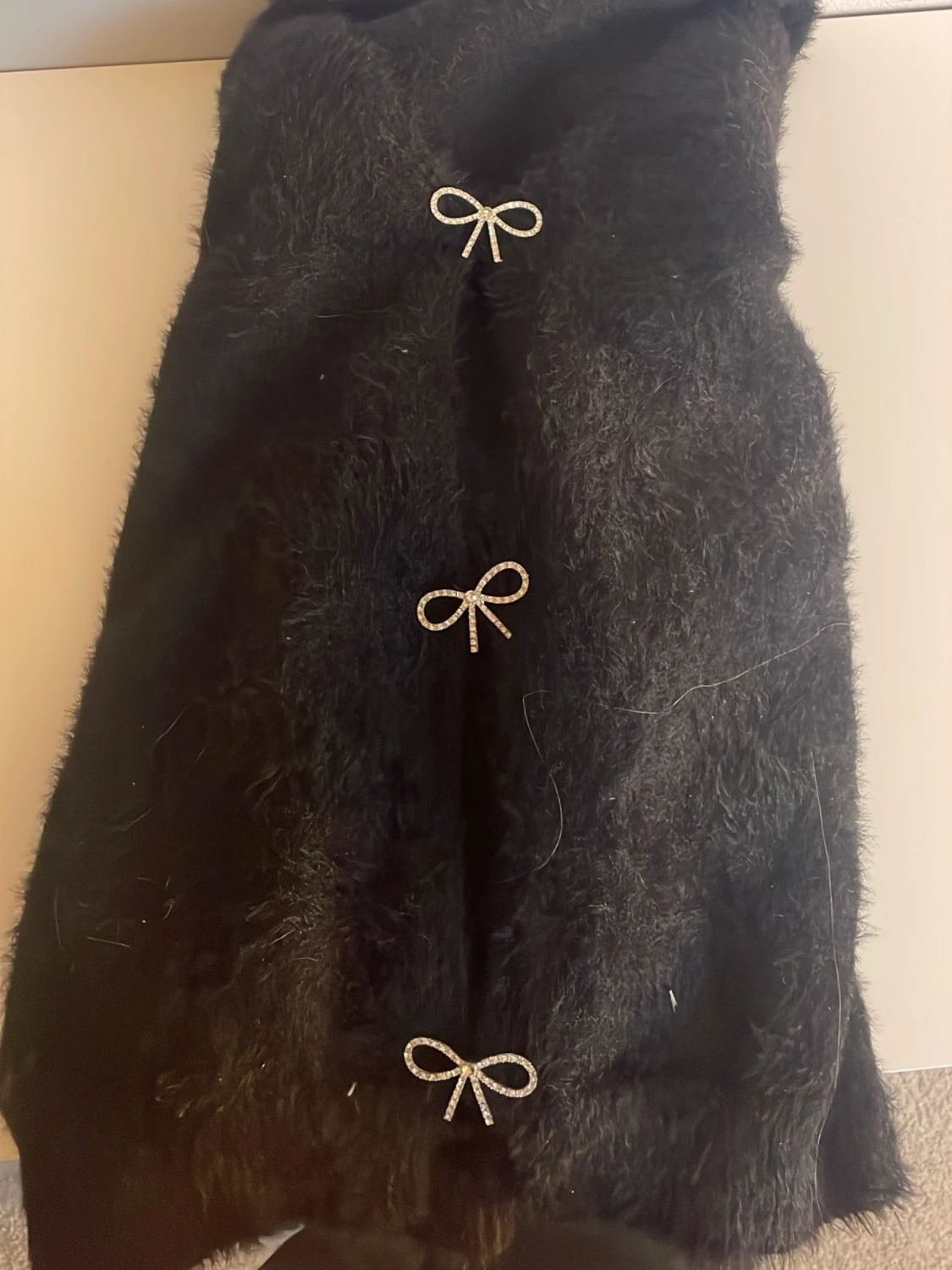 Svart pälskofta med rosettknäppning