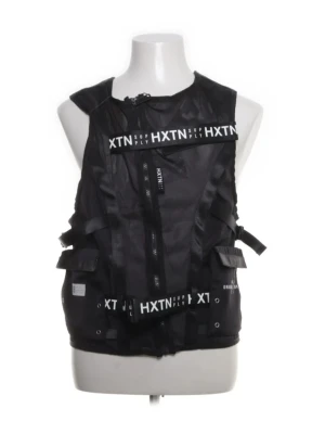 Svart utility-väst från HXTN Supply - Utility-väst i svart från HXTN Supply med vita logotexter och justerbara remmar på sidorna. Västen har flera spännen och dragkedjor samt detaljerade band med tryck. Tillverkad i ett lätt, slitstarkt material som ger en streetwear-inspirerad look.