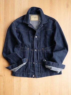 Stevenson Overall Co. Selvedge denim jacket type 2, size 42/M - Snygg mörkblå jeansjacka från Stevenson Overall Co. med klassisk krage, kontrastsömmar och knäppning framtill. Jackan har två bröstfickor och justerbara ärmslut. Perfekt för en cool och avslappnad stil.