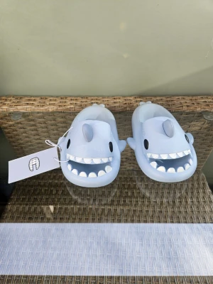 Sharkslippers - Säljer dessa hajtofflor i storlek 25. Har andra storlekar mellan 23-32 