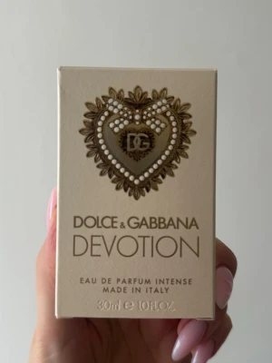 Dolce & Gabbana Devotion intense parfym - Lyxig parfym från Dolce & Gabbana, Devotion Eau de Parfum Intense. Flaskan är fyrkantig i glas med guldigt lock och dekorerad med ett detaljerat hjärta i guld. Doften kommer i en elegant förpackning med samma hjärtdetalj. Volym: 30 ml. Testsprutad en gång.