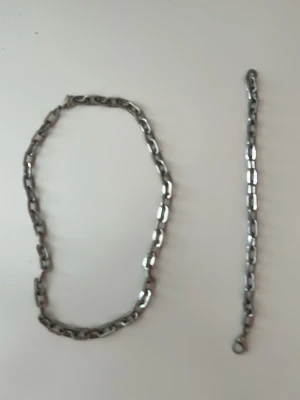 Kedjehalsband och kedjearmband i silverfärgad metall - Säljer ett chunky halsband i silverfärgad metall med rejäla länkar. Halsbandet har en industriell känsla och passar perfekt för dig som gillar en tuffare stil. Länkarna är avlånga och blanka, vilket ger ett coolt uttryck.
