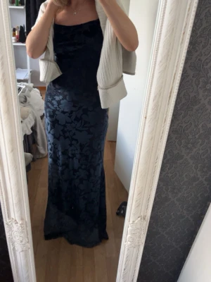 Mörkblå långklänning Bikbok S - Säljer en mörkblå blommig långklänning från Bik Bok, färgen skiftar i olika ljus som man ser på bilderna💙🩵 