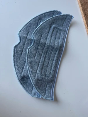 Blå mopptillbehör till robotdammsugare - Två stycken blå mopptillbehör i mikrofiber, anpassade för robotdammsugare. De har en böjd form och sydda kanter för att passa in i moppsystemet. Perfekt för att hålla golven rena och fräscha.