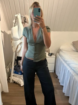Olivgrön blus med v-ringning - Så snygg grön blus med djup v-ringning. Perfekt i sommar!! Helt ny med prislapp kvar, säljer då den inte kommit till användning💕