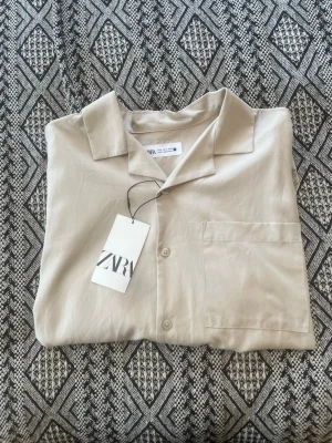 Zara Skjorta  - En somrig, oanvänd Zara skjorta. Den är avslappnad i passformen och perfekt för varma dagar! För mer frågor eller funderingar är det bara att kontakta! Mvh SecondTreasures 🪎