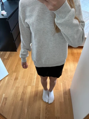 Ljusgrå hoodie med tryck - Säljer en ljusgrå hoodie i mjukt material med huva och ribbade muddar vid ärmslut och nederkant. På ryggen finns ett diskret tryck i form av en discolampa och så står de iconic,Perfekt för en avslappnad och stilren look. Från Gina tricot använd fåtal gånger.