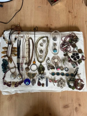 Stort smyckespaket med vintage, boho och Y2K-inspirerade smycken! 💍✨ - Blandning av halsband, ringar, armband, hängen, berlocker, broscher och accessoarer i olika stilar. Flera unika statement-smycken med pärlor, naturstenar och vintagekänsla – perfekt för dig som älskar att mixa olika stilar eller vill sälja vidare. Säljs som ett paket. Inget äkta silver. Kommer budas ut på min live 15 juli 19.00.
