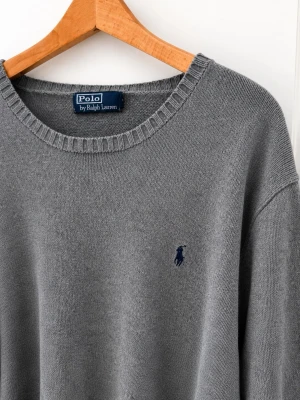 Grå stickad tröja Polo Ralph Lauren - Klassisk grå stickad tröja från Polo Ralph Lauren med rund halsringning och ribbade muddar. Tröjan har den ikoniska mörkblå logotypen broderad på bröstet. Köpt på Vinted 