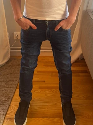 Mörkblå slim fit jeans  - Snygga mörkblå slim fit jeans från Garcia i stl 164 med klassiska femficksdetaljer och coola bakfickor med vinklade sömmar. Jeansen har en modern passform och är tillverkade i ett stretchigt denim-material som sitter skönt och följer kroppen.