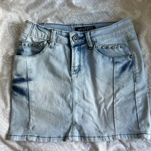 Ljusblå jeanskjol med nitar från Miss Vivi  - Ljusblå jeanskjol från Miss Vivi💓Så snygg och unik med nit detaljer🩵Lappen på fickan där bak är lite sliten men ingen man tänker på. Annars är kjolen i perfekt skick. Passar mig som bär xs