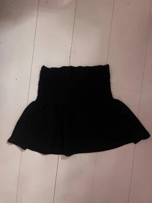 Svart kortkjol med ribbad resår - Svart kortkjol med bred ribbad resår upptill. Självt använt som topp. Jätte skön och bekväm. Lite nopprig som går att ta bort men inga defekter. Skriv vid fler frågor!