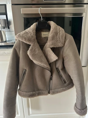 Beige teddy / bikerjacka - Mysig beige teddyjacka från Stradivarius med bred krage och dragkedja framtill. Jackan har två snedställda fickor med dragkedja och fluffig fuskpäls på insidan, kragen och nederkanten. Jackan är använd enstaka gånger men utan några tecken på användning  🩷