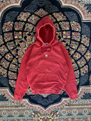 Russell hoodie med broderad symbol - Säljer en cherry hoodie från Russell Athletic med broderad vit symbol på bröstet. Klassisk känguruficka framtill och justerbar huva med dragsko. Perfekt för dig som gillar streetwear och vill ha en enkel men snygg look.