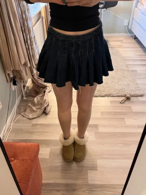 Mörkblå plisserad jeanskjol - Säljer en mörkblå kort plisserad jeanskjol. Använd endast en gång så i fint skick. Pris kan diskuteras💕