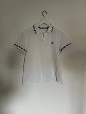 Moncler piké - Hej nu säljer vi denna otroligt fina autentiska moncler piké i en vit färg. Storlek på denna är S. Skick 9/10 inga skador eller defekter. För fler frågor eller funderingar är det bara att höra av sig. 