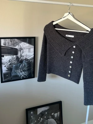 Mörkgrå stickad topp från Zara - Säljer min jättefina trendiga stickade topp från Zara på grund av att den inte kommer till användning längre. Den är i storlek XS🩶