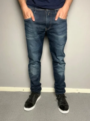 Mörkblå replay hyperflex jeans - Snygga mörkblå slim fit jeans med lätt tvättade detaljer och snygg fade. Storlek W31 L34. Mycket bra skick, skickar snabbt efter att du har beställt. Modellen är 175cm och väger 67kg. (Beställ helst med PostNord eller instabox)