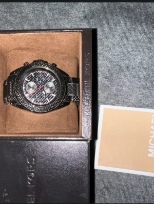 Michael Kors klockask - Säljer en snygg och stilren klocka från Michael Kors i svart med klockasken. 