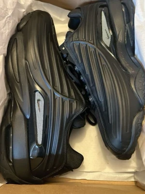 Svarta nocta sneakers - Säljer ett par svarta sneakers med futuristisk design och reflekterande detaljer. Skorna har en chunky sula och ovandel i syntetmaterial med meshpaneler. Perfekta för dig som gillar streetwear och vill sticka ut.