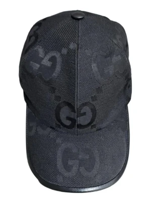 Svart keps  med GG-mönster - Snygg svart keps med det klassiska GG-monogrammet över hela kepsen. Kepsen har böjd skärm med läderdetalj runt kanten och är tillverkad i ett slitstarkt tyg. Perfekt accessoar för dig som vill ha en exklusiv och trendig look.