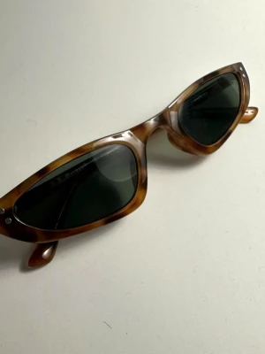 Coola smala cateye solglasögon A.J Morgan Eyewear - Ett par smala solglasögon i tortoise färg och svart glas. Endast använda ett fåtal gånger så i mycket bra skick. 