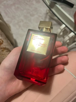 Maison Francis Kurkdjian Baccarat Rouge 540 - Lyxig parfymflaska i rött glas med guldfärgat lock och etikett. Märket är Maison Francis Kurkdjian och doften är Baccarat Rouge 540 Extrait de Parfum. Flaskan har en elegant, fyrkantig form och detaljer i metall som ger en exklusiv känsla. 200 ML, har sprejat 10 gånger 