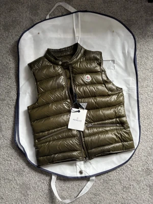 Moncler väst  - Snygg olivgrön dunväst från Moncler. Köpte den från Care of Carl kommer med den boxen och Moncler påsen. Är lite för liten för mig nu det är därför jag säljer den. Fråga bara om något som mer bilder eller något mer nfc funkar. 
