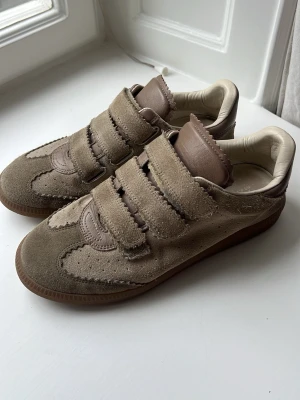 Beige sneakers med kardborreband - Isabel Marant Beth Sneakers i brunt mocka med lite kakhi och rosa toner. Använda endast ett fåtal gånger. Nypris ca 5000kr. 