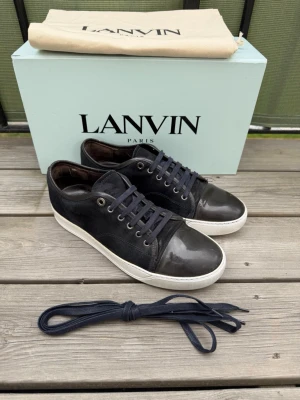 Lanvin - Lanvin dbb1 patent cap toe marinblå | storlek 6 eu40 sitter som 41-42 innermått 27cm | bra skick lite vitt på cap toen som går bort | lite slitet snöre längst ut men inget sönder | bara skor medföljer | pris går att diskutera vid snabb affär | skorna är vårdade med whitening cream |