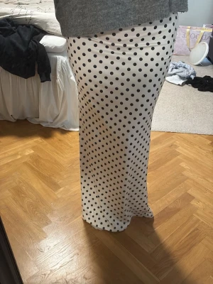 Vit långkjol med svarta prickar - Jättefin kjol, aldrig använd! skulle säga att den passar från xs-m, då den formar sig lätt till kroppen men endå är stretchig!