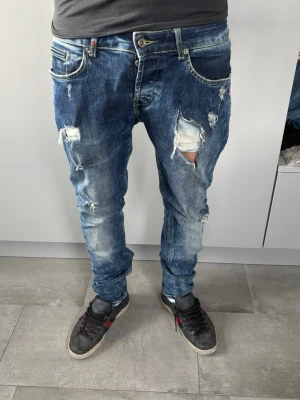 Dondup jeans - Säljer nu ett par riktigt sjysta Dondups. ett ganska stort hål på ena benet därav Priset. Modellen på bilden väger 76kg och är 181cm lång. Bara att höra av er vid frågor eller funderingar!