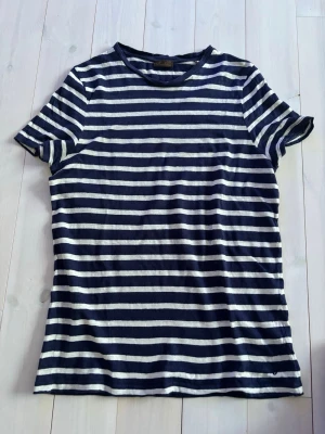 Stenströms - Exklusiv Randig marinblå t-shirt  - Snygg t-shirt från klassiska Stenströms med marinblå och vita horisontella ränder. Klassisk passform med rund hals och korta ärmar. Perfekt för en avslappnad stil och enkel att matcha med jeans eller shorts. Skön kvalitet. Original pris 1799kr