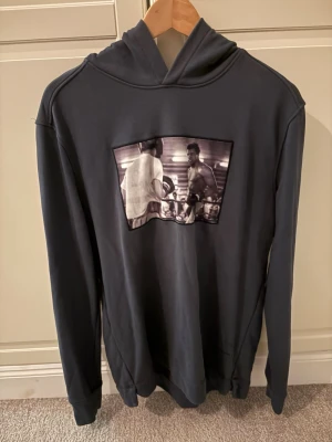 Mörkgrön/blå hoodie Limitato - Snygg hoodie med huva och ett stort tryck på bröstet som visar ett boxningsmotiv i svartvitt. Hoodien har långa ärmar och ribbade muddar. Modellen är sällsynt och i väldigt bra skick. Skicka dm för fler bilder😄