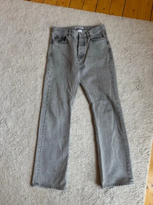 Hope Rush 28” - Gråa jeans från Hope i modellen Rush. Jeansen har regular fit med lätt bootcut i benslutet, vilket ger en rak passform genom låret och en något vidare öppning nedtill. 