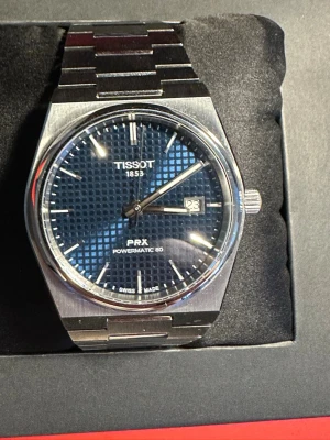 Tissot PRX Powermatic 80 blå urtavla  - Säljer min PRX powermatic 80 då jag fick en likadan i present nyligen. Nyskick, använts 3 gånger. Inga skador eller liknande. Låda följer med tillsammans med förväntade attiraljer iklsv 3 länkar. Inga skambud. Nypris 9200 kr