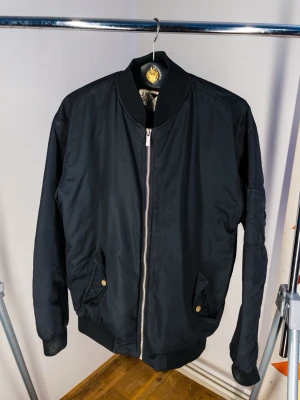 Bomber Jacka - snygg bomber jacka från Junkyard i storlek S (passar även M) har ett jätte litet bränn märke på höger arm som du kan se på sista bilden!