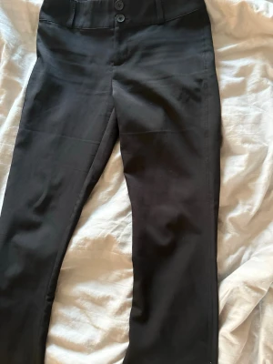 Svarta kostymbyxor med fickor - Snygga svarta kostymbyxor med bootcut. Tyvärr för stora. Använt två gånger.