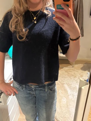 Svart stickad topp med kort ärm - Mysig svart stickad topp med korta ärmar och rak passform. Enkel och stilren design som passar till mycket. Perfekt att matcha med jeans eller kjol för en avslappnad look. Från Gina tricot, använd 2 gånger 