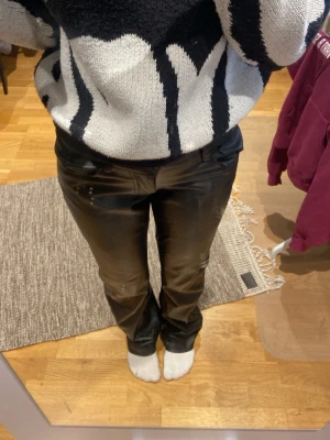 Svarta skinnbyxor med raka ben - Säljer ett par svarta manchesterbyxor med klassisk rak passform och normal midja. Byxorna har fickor fram och bak samt bälteshällor. Perfekta för dig som vill ha en stilren och tidlös look med lite retrovibe.