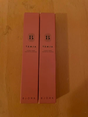 BJÖRK Tämja flytande hårtämjare x 2 - Två rosa förpackningar med BJÖRK Tämja, en flytande hårtämjare som hjälper till att fixa och tämja håret. Förpackningarna är smala och stilrena med svart text och logga. Perfekt för dig som vill ha kontroll på småhår och friss.
