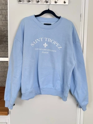 Y2K ljusblå sweatshirt med tryck, stl M - Babyblå/ljusblå sweatshirt med tryck och normal passform. Så snygg och vårig till ett par jeans eller yogapants. Använd en gång och tvättad en gång.