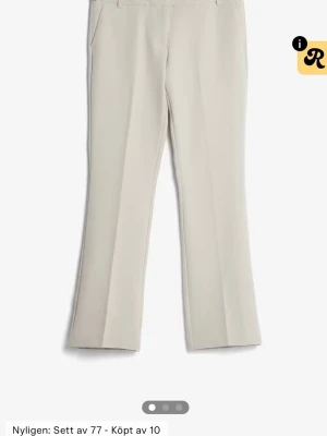 Beige kostymbyxor med pressveck - Lågmidjade beige kostymbyxor med raka ben och pressveck framtill. Aldrig använda.