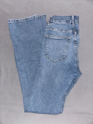 Ljusblå bootcut jeans - Snygga ljusblå bootcut jeans med klassisk femficksdesign och normalhög midja. Jeansen har en lätt tvättad look och raka ben som går ut lite nertill. Perfekta för en avslappnad och trendig stil. Byxorna är ca 30cm rätt över och innebenslängden är ca 77cm❤️ Säljer eftersom dessa inte längre passar mig. Skriv gärna innan ni köper❤️