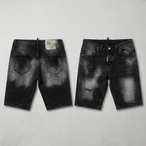 Dsquared2 ”Skater Jean” Shorts Special Edition - Coola svarta jeansshorts från Dsquared2 med slitna detaljer och blekta partier. Klassisk femficksmodell med knappgylf och röd logotagg vid fickan. Perfekta för en avslappnad streetstil.