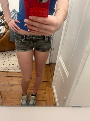 Svarta jeansshorts från Abercrombie - Supersnygga svarta jeansshorts från Abercrombie & Fitch med slitna detaljer och kontrastsömmar. Klassisk femficksmodell med låg midja och stora bakfickor med broderad logga. Perfekta till sommaren och riktigt trendiga.