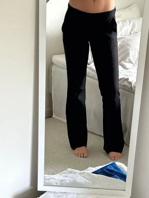 Svarta kostymbyxor - Snygga svarta kostymbyxor med rak passform och normal midja. Byxorna har en klassisk look och är perfekta för en clean och stilren outfit. Materialet ser ut att vara ett tunt tyg som ger en dressad känsla.