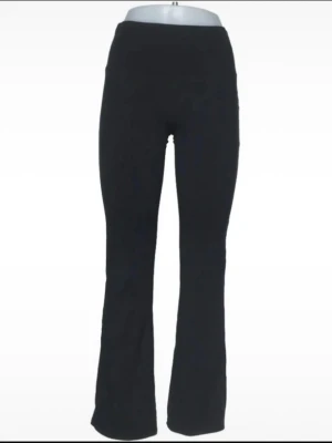 Svarta bootcut yoga byxor  - Säljer ett par svarta yoga byxor med bootcut-modell och hög midja. De är stretchiga och sitter tajt över låren men har utsvängda ben. Perfekta för dig som gillar en enkel men trendig look. Materialet är mjukt och bekvämt. Väldigt stretchiga. 2