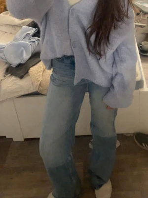Ljusblå raka jeans med hög midja - Säljer ett par ljusblå jeans med hög midja och raka ben. Jeansen har klassisk femficksdesign och är tillverkade i ett mjukt denimtyg. Perfekta för en avslappnad och trendig look.