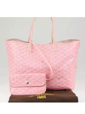 Rosa mönstrad toteväska-g o y a-rd - Snygg rosa toteväska med ikoniskt mönster och matchande liten clutch. Väskan har två handtag och är tillverkad i ett tåligt material med glansig finish. Perfekt för dig som vill ha plats för allt och samtidigt sticka ut med en trendig accessoar. Ej äkta, använd endast 2ggr